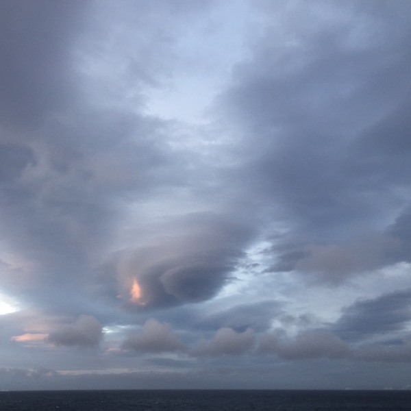 Lenticular clouds (Altocumulus lenticularis), according to Google, are stationary lens-shaped clouds that form in the troposphere, normally in perpendicular alignment to the wind direction.