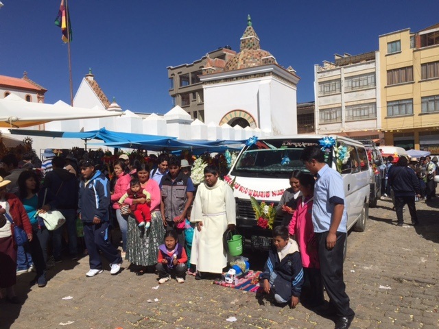 Here's a happy family posing with the Priest who blessed their van for ~$10.